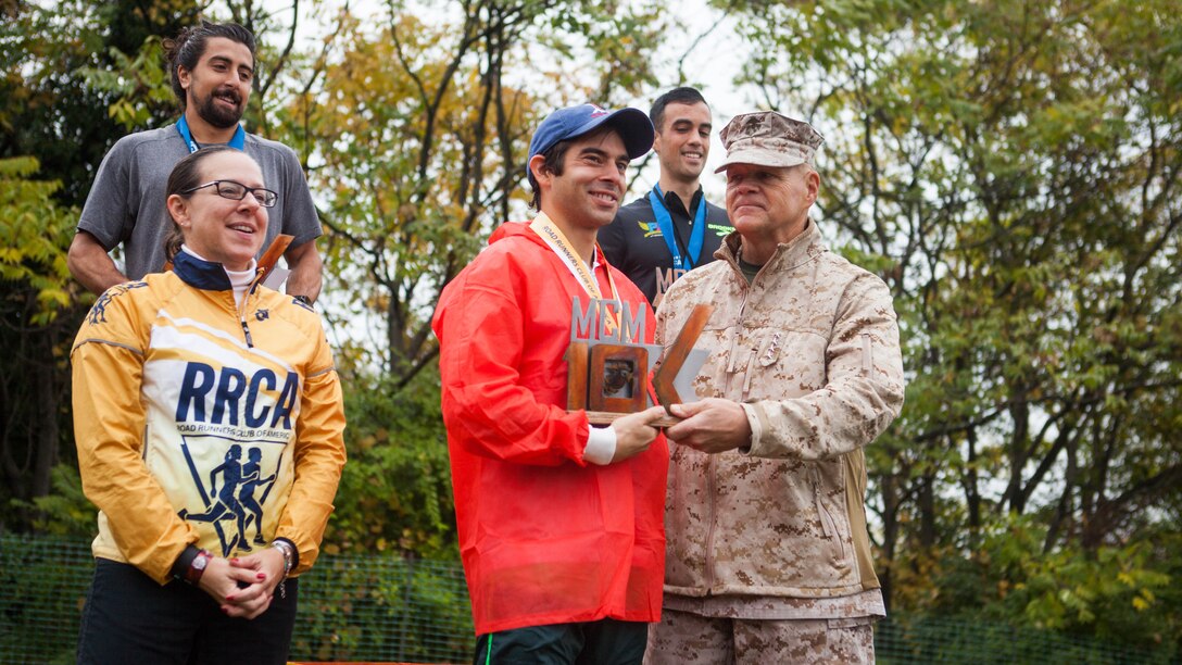 Jack Dasilva, the winner of the Marine Corps Marathon 10K, accepts his trophy from Gen. Robert Neller, the 37th Commandant of the Marine Corps, in Arlington, Virginia, Oct. 25. Dasilva finished the 10-kilometer race in a little over 34 minutes. 