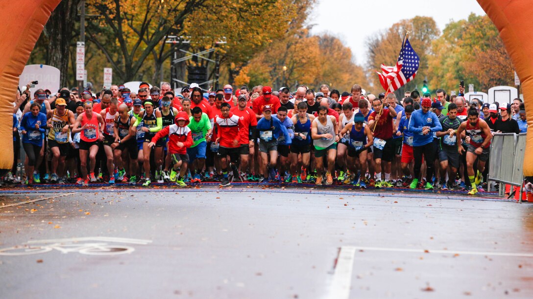 Runners sprint through the starting line during the Marine Corps Marathon 10K race Oct. 25, 2015, in Washington. More than 10,000 runners participated in the 10-kilometer race as part of the Marine Corps Marathon event, with more than 30,000 participants running the 26.2-mile marathon. 