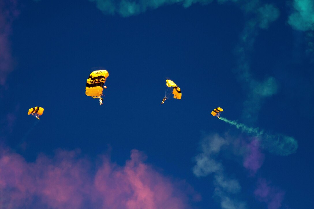 Candidates trying out for the U.S Army Parachute Team, the Golden Knights, leave smoke trails as they glide to a drop zone while practicing precision landings in Laurinburg, N.C., Oct. 20, 2015. U.S. Army photo by Staff Sgt. David Meyer