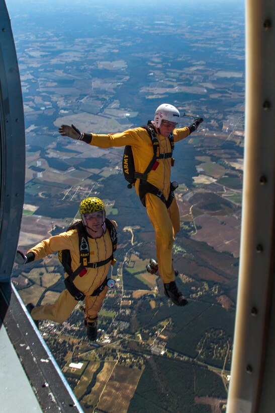 Army Staff Sgt. Nicholas Berkner, left, and Spc. Joe Bradshaw, exit a UV-18 Twin Otter aircraft over Laurinburg, N.C., Oct. 20, 2015. The two are candidates practicing a jump during tryouts to become a member of the U.S Army Parachute Team the Golden Knights. U.S. Army photo by Staff Sgt. David Meyer