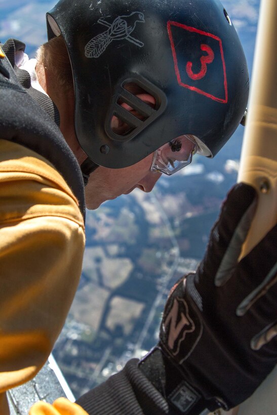 Army Sgt. Daniel Gerlach looks out a UV-18 Twin Otter aircraft over Laurinburg, N.C., Oct. 20, 2015, to find the spot for his jump. He is a candidate to become a member of the U.S Army Parachute Team the Golden Knights. U.S. Army photo by Staff Sgt. David Meyer