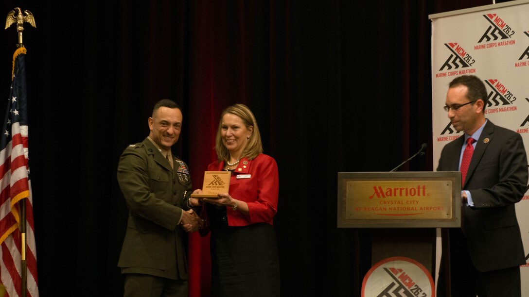 Col. Joseph M. Murray, commander, Marine Corps Installations National Capital Region-Marine Corps Base Quantico, presents Bonnie Carroll with a plaque during the Marine Corps Hall of Fame dinner and ceremony at the Hyatt Regency Reagan National Airport in Crystal City, Va., Oct. 23, 2015. Carroll, a retired Air Force major, brings more than 200 runners every year to the marathon through her charity, Tragedy Assistance Program for Survivors. She was given the title “ambassador,” or an individual who has been apart of the event in interesting ways, during the diner.
