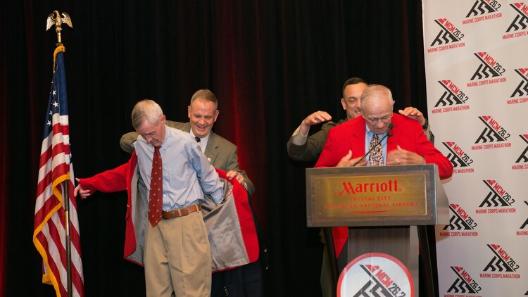 Will Brown (left) and Alfred Richmond (right) receive their “Groundpounder” coats for participating in all 40 Marine Corps Marathons during the Marine Corps Hall of Fame dinner and ceremony at the Hyatt Regency Reagan National Airport in Crystal City, Va., Oct. 23, 2015. In addition to Richmond and Brown receiving their coast, news anchor Chas Henry and Olympian Jeff Galloway were inducted into the Marine Corps Marathon Hall of Fame at the dinner and individuals were given the title “ambassador.”