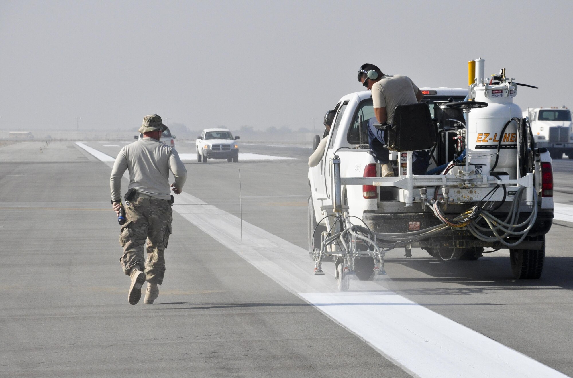 Airmen from the 455th Expeditionary Civil Engineer Squadron paint the runway markings Oct. 22, 2015, at Bagram Airfield, Afghanistan. The paint used is mixed with reflective beads to ensure that the markings can be seen by the pilots coming and going from Bagram in support of Operation Freedom’s Sentinel and NATO’s Resolute Support mission. (U.S. Air Force photo by Tech. Sgt. Nicholas Rau/Released)