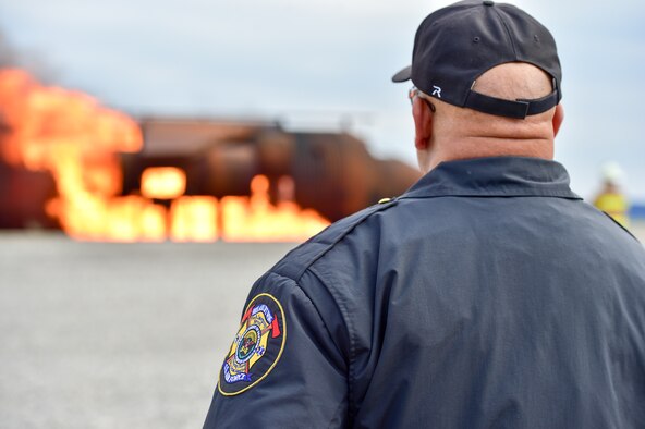 910th Civil Engineer Squadron Fire Department Chief Anthony Wells observes the response of his unit members to a simulated aircraft accident during the second annual Feel the Heat event here, Oct. 22, 2015. Feel the Heat is an interactive training and demonstration event involving the 910th Airlift Wing and the American Red Cross Lake to River Chapter. During the event, the 910th Civil Engineer Squadron Fire Department ignited a mock training aircraft and responded with vehicles and personnel to combat the blaze and rescue victims. (U.S. Air Force photo/Eric M. White)