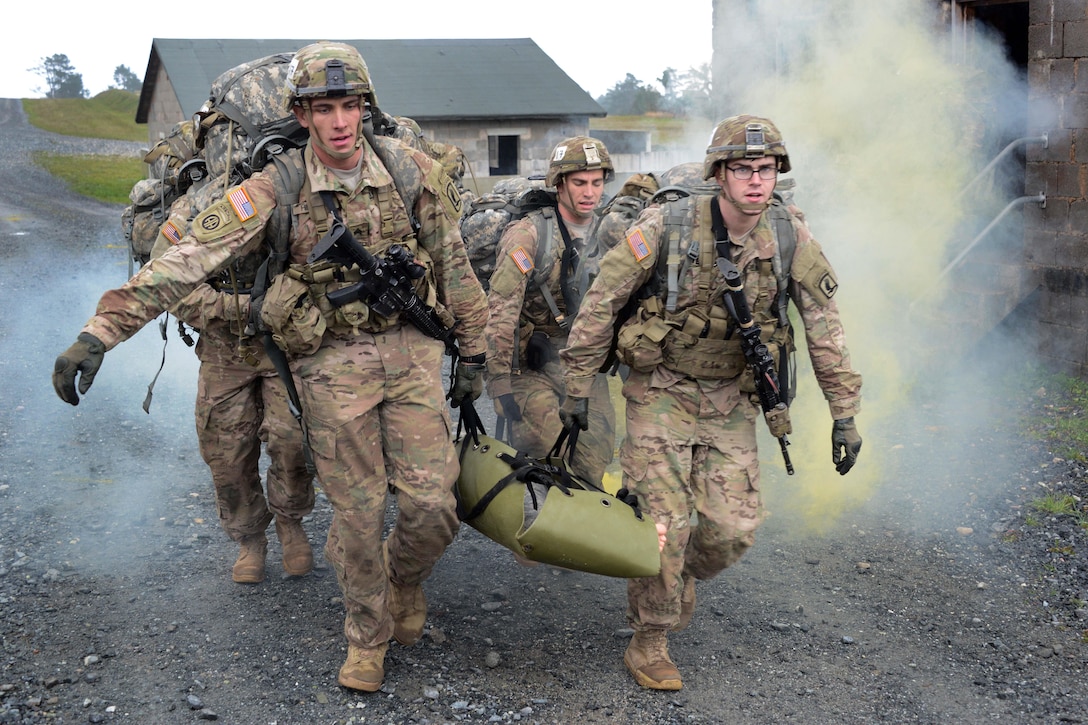 U.S. soldiers carry a mannequin during the European Best Squad Competition at the Grafenwoehr Training Area in Bavaria, Germany, Oct. 20, 2015. U.S. Army photo by Gertrud Zach