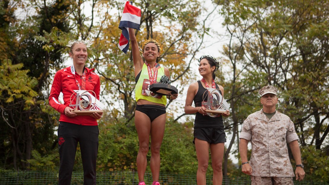 Gen. Robert Neller, the 37th Commandant of the Marine Corps, stands with the top female finishers of the 40th Marine Corps Marathon in Arlington, Va., Oct. 25, 2015. The top three male and female finishers each received a medal, a trophy and a wreath, which was made in Marathon, Greece. This year’s participants joined the 512,370 runners, who have completed the “Marathon of the Monuments” since its inaugural event in 1976.