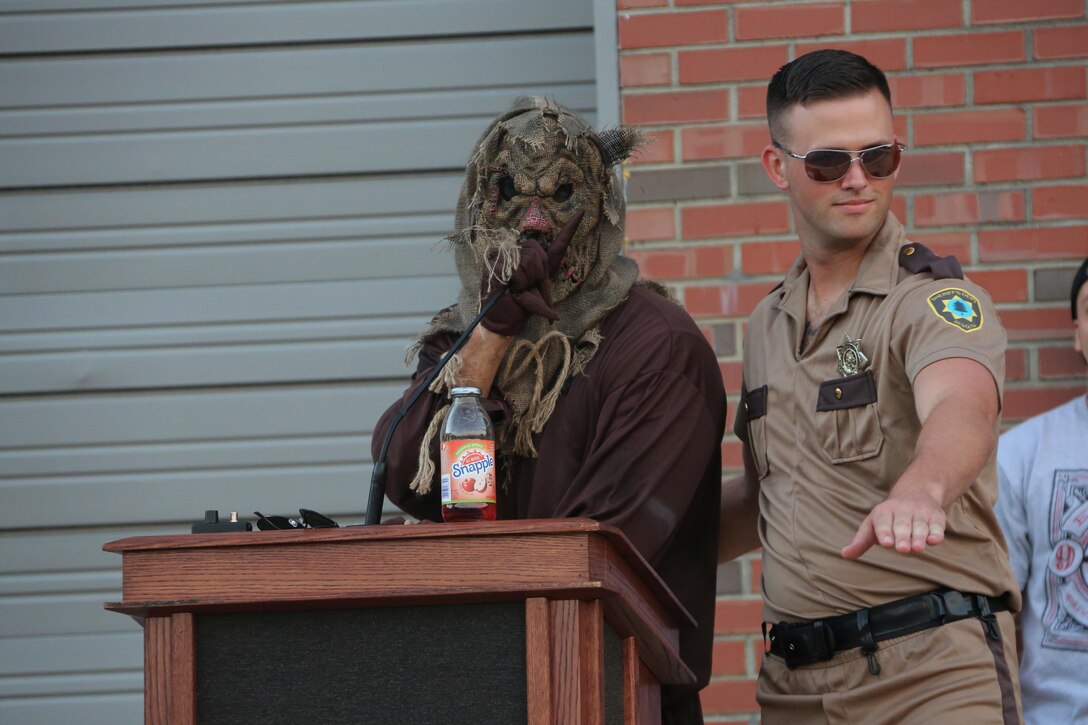 Marines dressed as a scarecrow and a police officer stand on stage during a costume contest at the Fall Family Festival hosted by Marine Air Control Squadron 2 at Marine Corps Air Station Cherry Point, N.C., Oct. 22, 2015.  More than 100 Marines, Sailors and family members gathered to kick off the fall season with a chili cook-off and costume contest as well as games, a movie and a bonfire. (U.S. Marine Corps photo by Cpl. N.W. Huertas/Released)