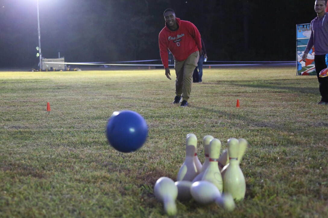 Lance Cpl. Jaylyn Smith throws a bowling ball at a set of pins while playing a game at the Fall Family Festival hosted by Marine Air Control Squadron 2 at Marine Corps Air Station Cherry Point, N.C., Oct. 22, 2015.  More than 100 Marines, Sailors and family members gathered to kick off the fall season with a chili cook-off and costume contest as well as games, a movie and a bonfire. Smith is a tactical air defense controller with MACS-2. (U.S. Marine Corps photo by Cpl. N.W. Huertas/Released)