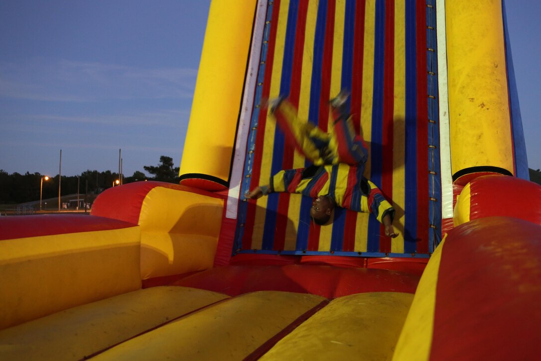 Lance Cpl. Daijon Reason flips through the air before sticking to an inflatable Velcro sticky wall while wearing a Velcro suit during the Fall Family Festival hosted by Marine Air Control Squadron 2 at Marine Corps Air Station Cherry Point, N.C., Oct. 22, 2015.  More than 100 Marines, Sailors and family members gathered to kick off the fall season with a chili cook-off and costume contest as well as games, a movie and a bonfire. Reason is a tactical air defense controller with MACS-2. (U.S. Marine Corps photo by Cpl. N.W. Huertas/Released)