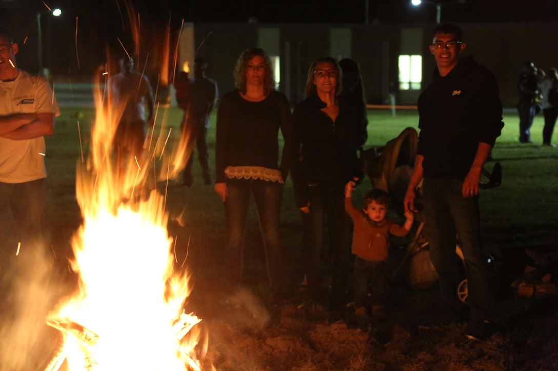 Marines stand with their families as they warm-up by a bonfire during the Fall Family Festival hosted by Marine Air Control Squadron 2 at Marine Corps Air Station Cherry Point, N.C., Oct. 22, 2015.  More than 100 Marines, Sailors and family members gathered to kick off the fall season with a chili cook-off and costume contest as well as games, a movie and a bonfire. (U.S. Marine Corps photo by Cpl. N.W. Huertas/Released)