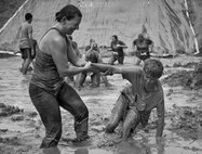 A mother helps her son up out of the mud and toward the finish line at the Pensacola Mud Run Oct 24. Active duty and reserve service members from many local military bases came out to get dirty in the five-mile, 20-obstacle challenge.  (U.S. Air Force photo/Tech. Sgt. Sam King)