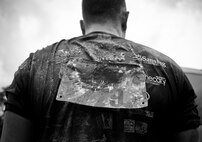 A competitor’s shirt and bib are caked with mud after completing the Pensacola Mud Run Oct 24. Active duty and reserve service members from many local military bases came out to get dirty in the five-mile, 20-obstacle challenge.  (U.S. Air Force photo/Tech. Sgt. Sam King)