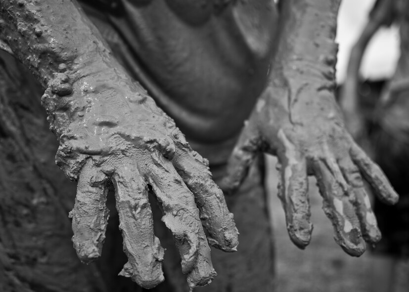 A competitor shows off his mud-coated hands after climbing through the last obstacle to finish the Pensacola Mud Run Oct 24. Active duty and reserve service members from many local military bases came out to get dirty in the five-mile, 20-obstacle challenge.  (U.S. Air Force photo/Tech. Sgt. Sam King)