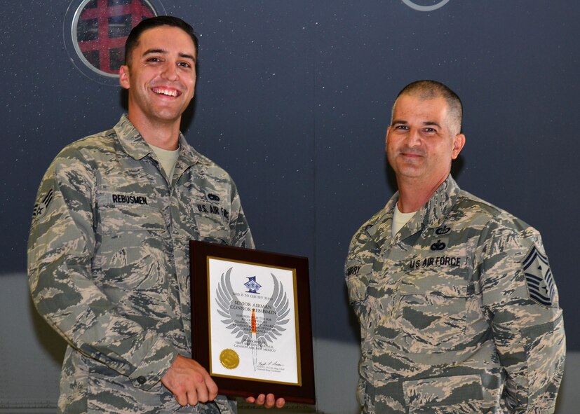 U.S. Air Force Senior Airman Connor Rebusmen, 27th Special Operations Aircraft Maintenance Squadron crew chief, stands with Senior Master Sgt. Bill Barry, 27th SOAMXS first sergeant, during his Diamond Sharp Award recognition Aug. 14, 2015, at Cannon Air Force Base, N.M. Rebusmen is an MC-130J crew chief assigned to the 9th Aircraft Maintenance Unit, who spends ample time setting the bar for community involvement within his squadron. (U.S. Air Force photo/Airman 1st Class Shelby Kay-Fantozzi) 