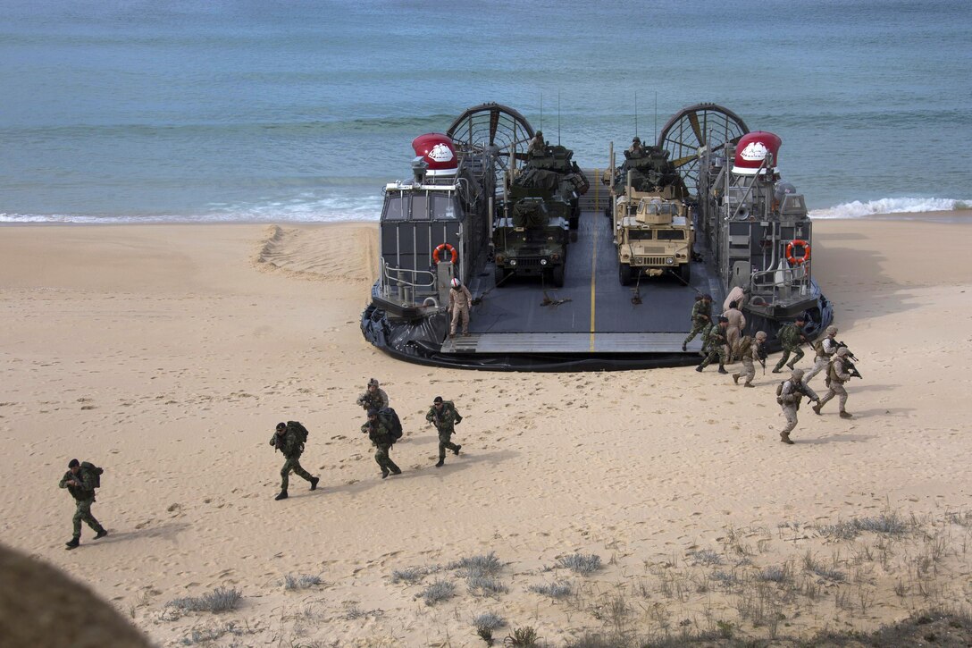 U.S. and Portuguese Marines offload from a Landing Craft Air Cushion on Pinheiro Da Cruz Beach, Portugal, Oct. 20, 2015, during Trident Juncture 15. U.S. Marine Corps photo by Cpl Jeraco Jenkins