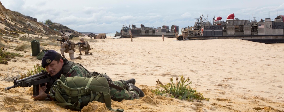A Portuguese Marine provides security for a Landing Craft Air Cushions on Pinheiro Da Cruz Beach, Portugal, Oct. 20, 2015. Marines participated in a combined amphibious assault exercise during Trident Juncture 15. U.S. Marine Corps photo by Sgt. Austin Long