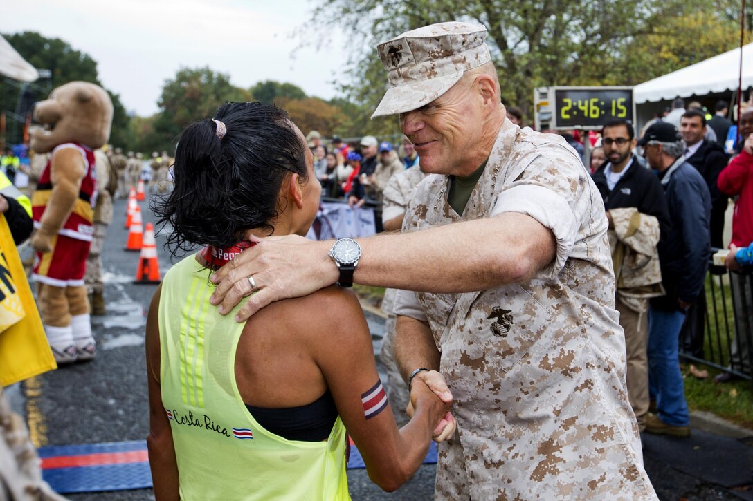 Marine Corps Commandant Gen. Robert B. Neller congratulates Jenny Mendez Suanca, the first woman finisher of the Marine Corps Marathon, in Arlington, Va., Oct. 25, 2015. Suanca completed the 26.2 course in 2:45:55. U.S. Marine Corps photo by Sgt. Gabriela Garcia