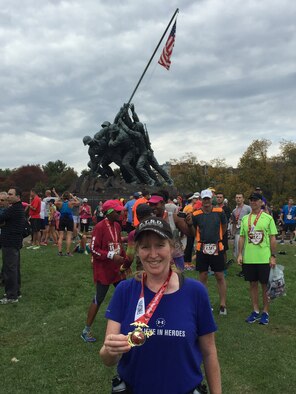 Shannon Collins with her medal in front of the Iwo Jima Memorial after completing the Marine Corps Marathon Oct. 25. 
