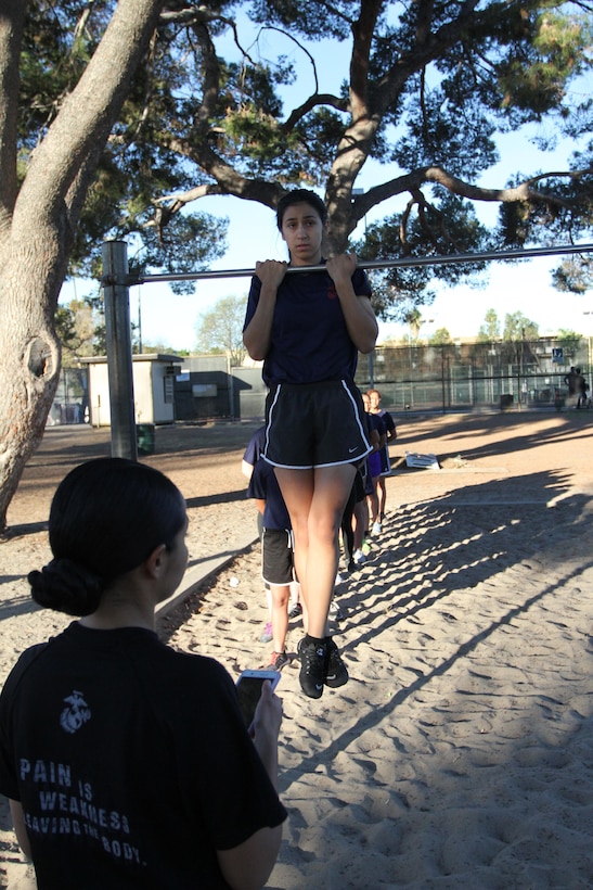 Staff Sgt. Mayra Hempel, recruiter with Recruiting Sub Station Van Nuys, Calif., times a poolee as she performs the flexed-arm hang during a female pool function at Recruiting Station Los Angeles, Oct. 24, 2015, to build camaraderie and spread knowledge about the Marine Corps. (Official U.S. Marine Corps photo/Released)