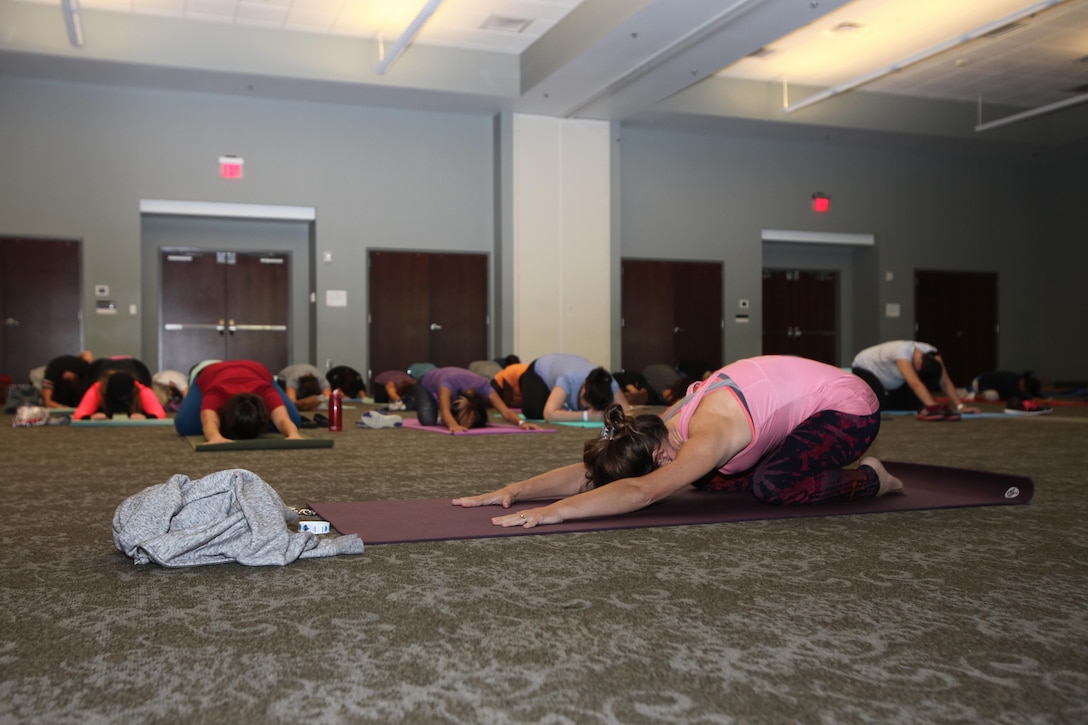 Spouses of active-duty service members hold a child’s pose during the annual Spouses Spa Day hosted by Marine Corps Family Team Building at Marine Corps Air Station Cherry Point, N.C., Oct. 22, 2015. During the event spouses of active-duty service members were pampered with facials, foot soaks and were given strategies to help them relax. Spouses enjoyed free yoga, fresh smoothies and mini spa treatments. MCFTB used the event as an opportunity to give the ladies a relaxing experience to combat the stresses of being a military spouse. (U.S. Marine Corps photo by Lance Cpl. Jason Jimenez/Released)