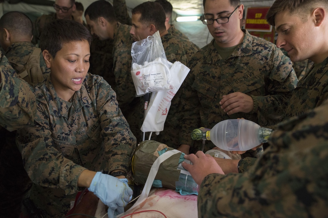 Navy Lt. Cmdr. Lorelie P. Flinn treats a patient during a shock trauma drill, part of Blue Chromite 2016, in Okinawa, Japan, Oct. 26, 2015. Flinn, a critical care nurse with 3rd Medical Battalion, 3rd Marine Logistics Group, is assisted by Navy Petty Officer 3rd Class Caleb Alkire, a team leader with Company B, 3rd Medical Battalion, and Petty Officer 3rd Class Ryan T. Badillo, also a team leader with the company. The shock trauma drill gave the Navy medical team an opportunity to practice stabilizing patients in an expeditionary setting. Blue Chromite, a massive amphibious exercise that unites all major subordinate elements within parts of III Marine Expeditionary Force, includes 3rd MLG, 3rd Marine Division, and 1st Marine Aircraft Wing. Flinn is from the Philippines; Alkire is from New Haven, Conn.; and Badillo is from Newport, N.C.  (U.S. Marine Corps photo by Cpl. Drew Tech/Released)