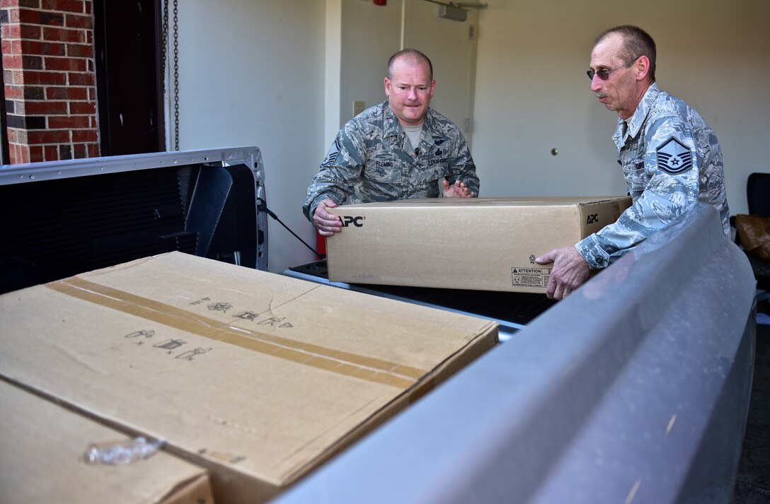 Senior Master Sgt. Don Fleming and Master Sgt. John Sauerwein, both with the 932nd Airlift Wing Force Support Squadron, load  computer battery backup systems into a truck as part of a larger move for the Local Area Network and Information Systems Flight partial relocation to building 4032, Scott Air Force Base.   The move will give the computer techs more space to work on computers and help ease some workload by having closer access to resources.  (U.S Air Force photo/ Christopher Parr)