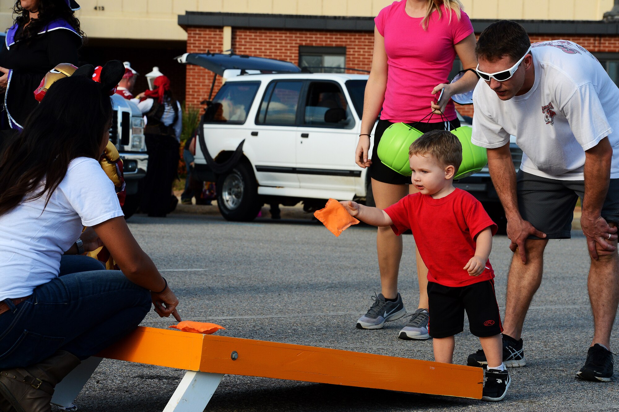 A Team Shaw child throws a bean bag toward a corn hole board during Boo Bash at Shaw Air Force Base, S.C., Oct. 24, 2015. The 20th Force Support Squadron hosted the event on base for Team Shaw families, providing an opportunity for parents to bring their children out to a trunk-or-treat, play games, and participate in a costume contest. (U.S. Air Force photo by Senior Airman Jonathan Bass/Released)