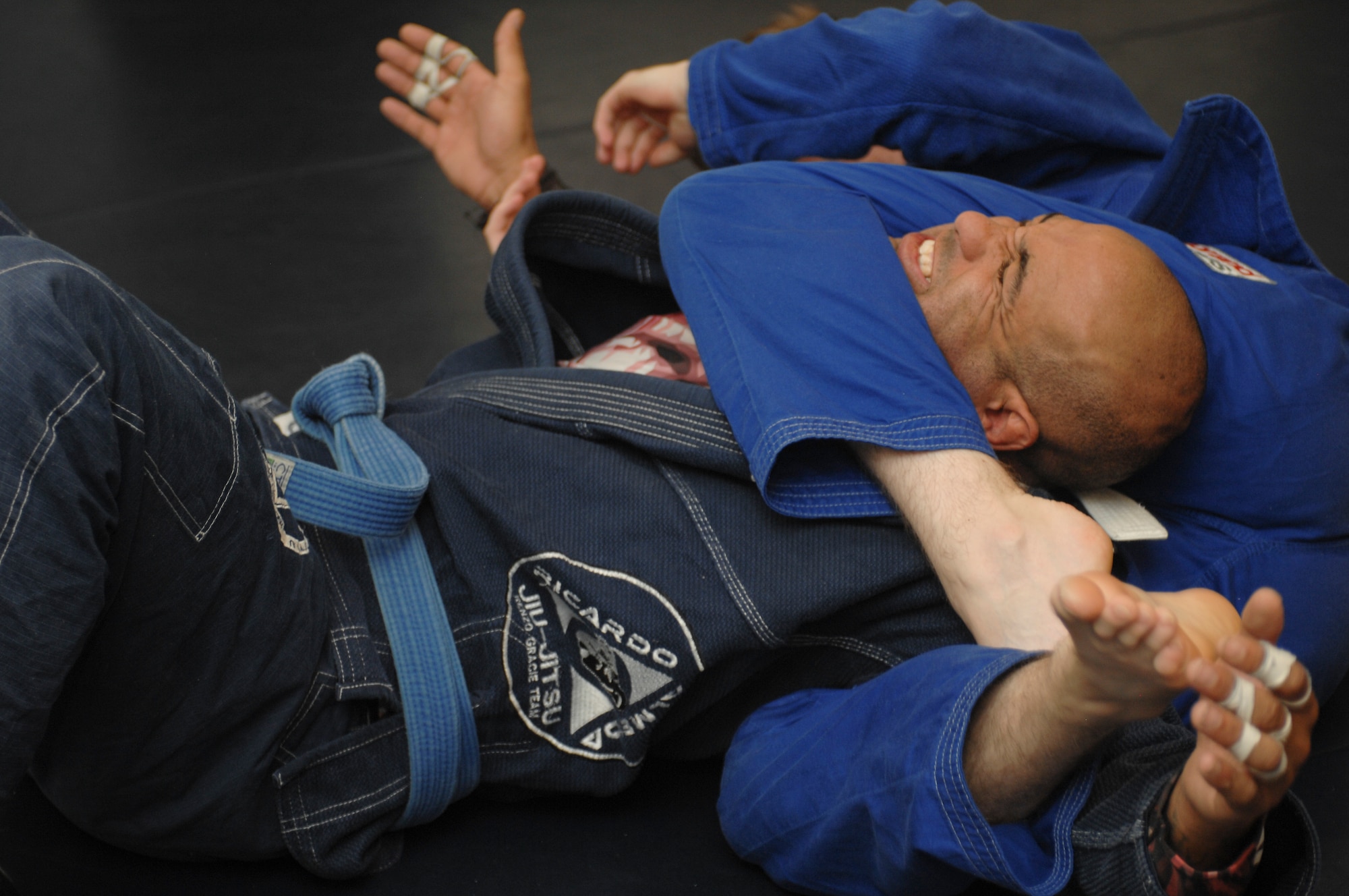 Garrett Clark, Air Force veteran and jiujitsu instructor, cringes while being choked during a Brazilian Jiujitsu  class at Davis-Monthan Air Force Base, Ariz., Sept. 30, 2015. Clark is a level 2 certified combatives instructor and has his blue belt through Endure Brazilian Jujitsu under Professor Bobbie Williams.  (U.S. Air Force photo by Airman Basic Nathan H. Barbour/Released)