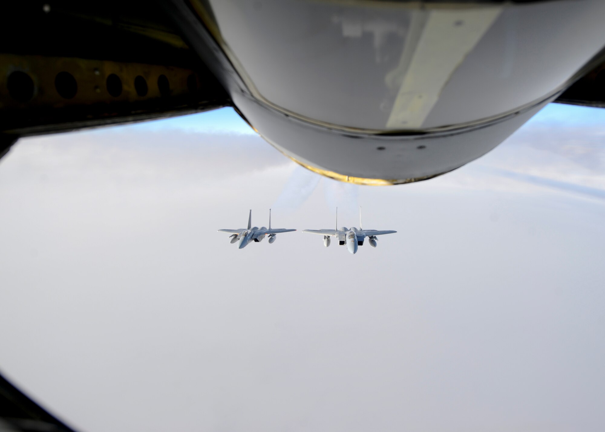 Two F-15 Eagles assigned to the 144th Fighter Wing, Fresno Air National Guard Base, California, fly behind a KC-135 Stratotanker after an aerial refueling mission, Oct. 20, 2015, over northern Canada. From Oct. 15 - 26, 2015, approximately 700 members from the Canadian Armed Forces, United States Air Force, United States Navy, and United States Air National Guard are deploying to Iqaluit, Nunavut, and 5 Wing Goose Bay, Newfoundland and Labrador for Exercise Vigilant Shield 16 (U.S. Air Force photo by Senior Airman Victor J. Caputo)