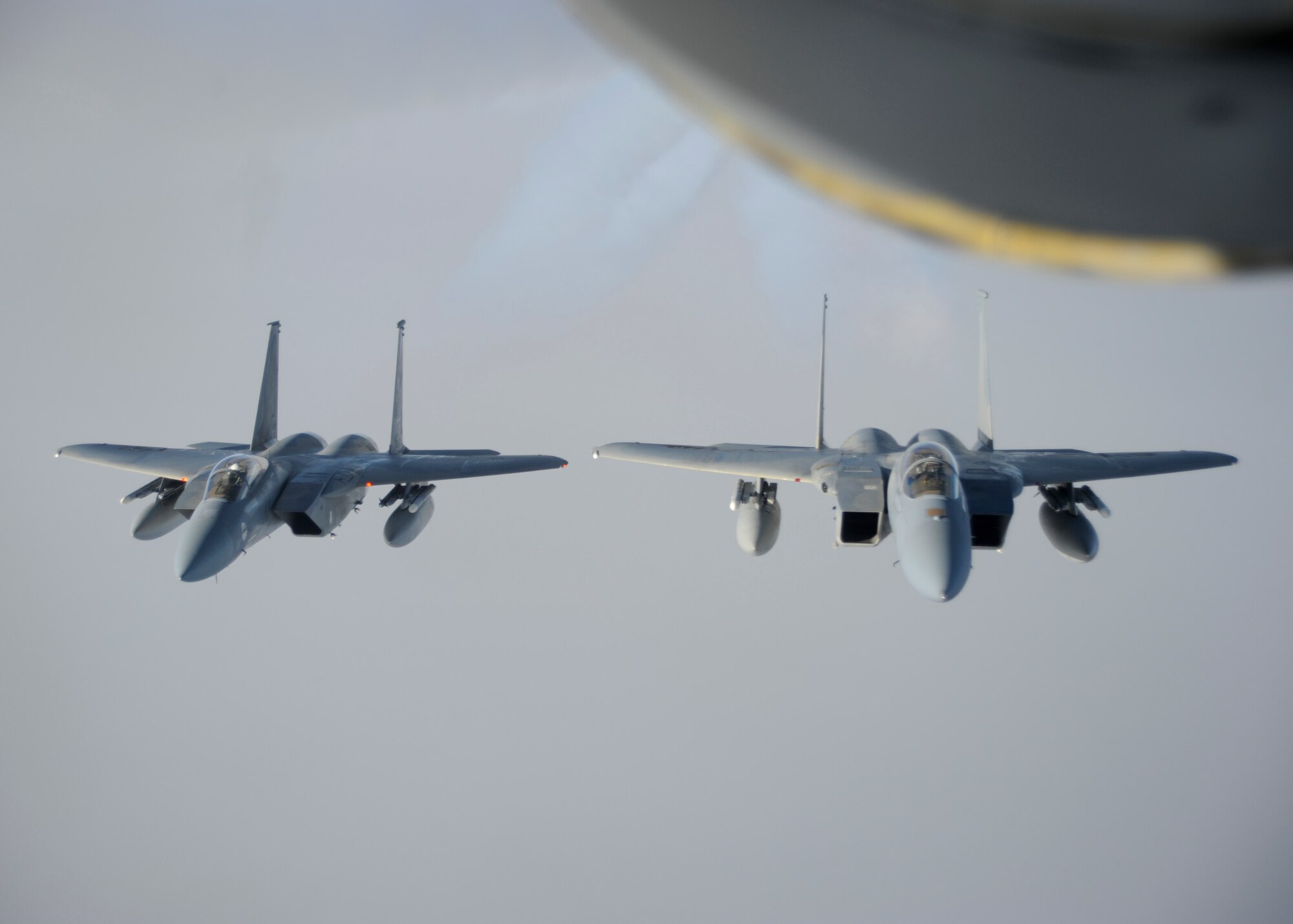 Two F-15C Eagles assigned to the 144th Fighter Wing, Fresno Air National Guard Base, California, fly in formation behind a KC-135 Stratotanker after a successful refueling mission, Oct. 20, 2015, over northern Canada. From Oct. 15 - 26, 2015, approximately 700 members from the Canadian Armed Forces, United States Air Force, United States Navy, and United States Air National Guard are deploying to Iqaluit, Nunavut, and 5 Wing Goose Bay, Newfoundland and Labrador for Exercise Vigilant Shield 16 (U.S. Air Force photo by Senior Airman Victor J. Caputo)
