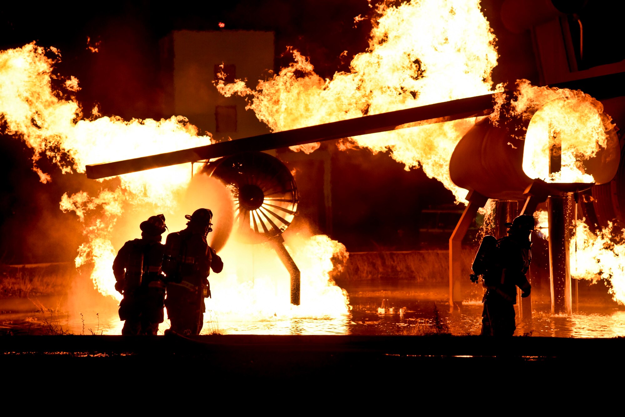 Base commanders and chiefs assist Fairchild firefighters in a controlled fire demonstration Oct. 22, 2015, on the flightline at Fairchild Air Force Base, Wash. Base leadership was invited to participate in a live fire demonstration where they suited up and learned how to correctly use the air tanks and fire hoses. (U.S. Air Force photo/Airman 1st Class Taylor Bourgeous)