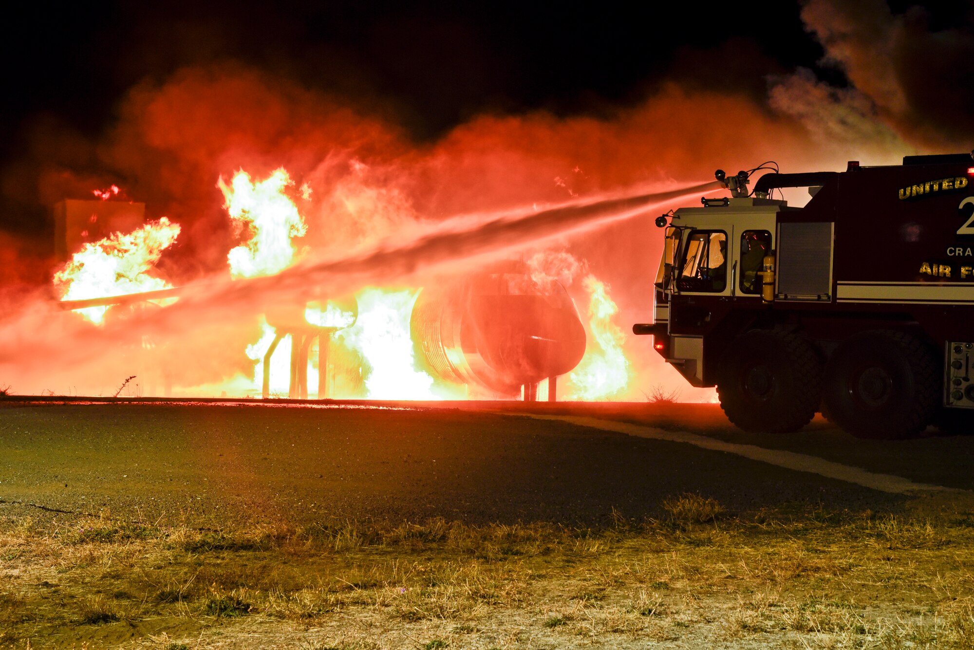 Base commanders assist firefighters in a controlled fire demonstration Oct. 22, 2015, on the flightline at Fairchild Air Force Base, Wash. Base leadership was invited to participate in a live fire demonstration to experience a firefighter’s mission firsthand as well as some of the training their job entails. (U.S. Air Force photo/Airman 1st Class Taylor Bourgeous)