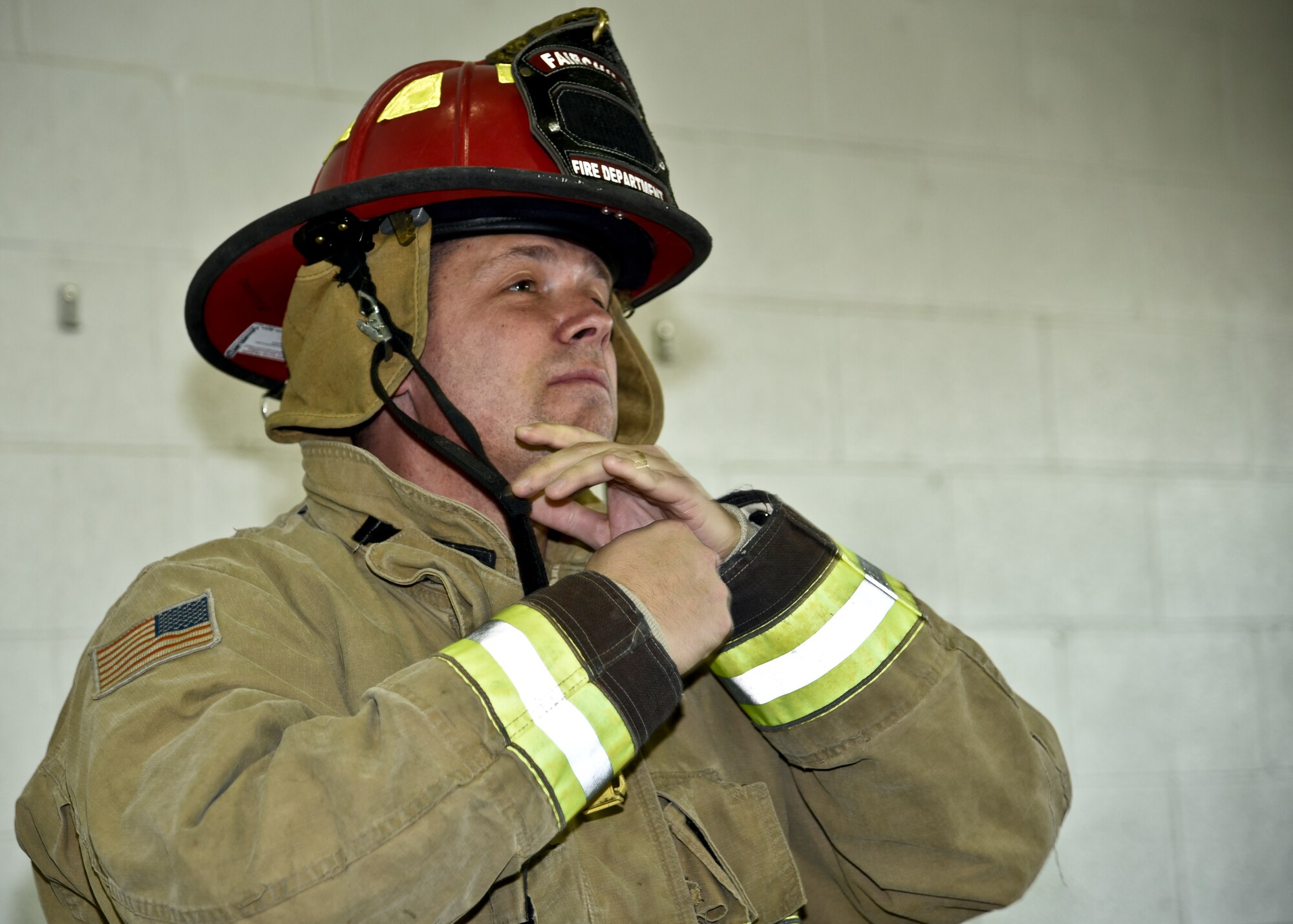 Col. Matthew Fritz, 92nd Air Refueling Wing vice commander, dons his fire helmet during a live fire demonstration Oct. 22, 2015, at the Fairchild Air Force Base fire department in Wash. Commanders and chiefs from various base units participated in a live fire demonstration as part of fire prevention month, which is held annually in October. (U.S. Air Force photo/Airman 1st Class Taylor Bourgeous)
