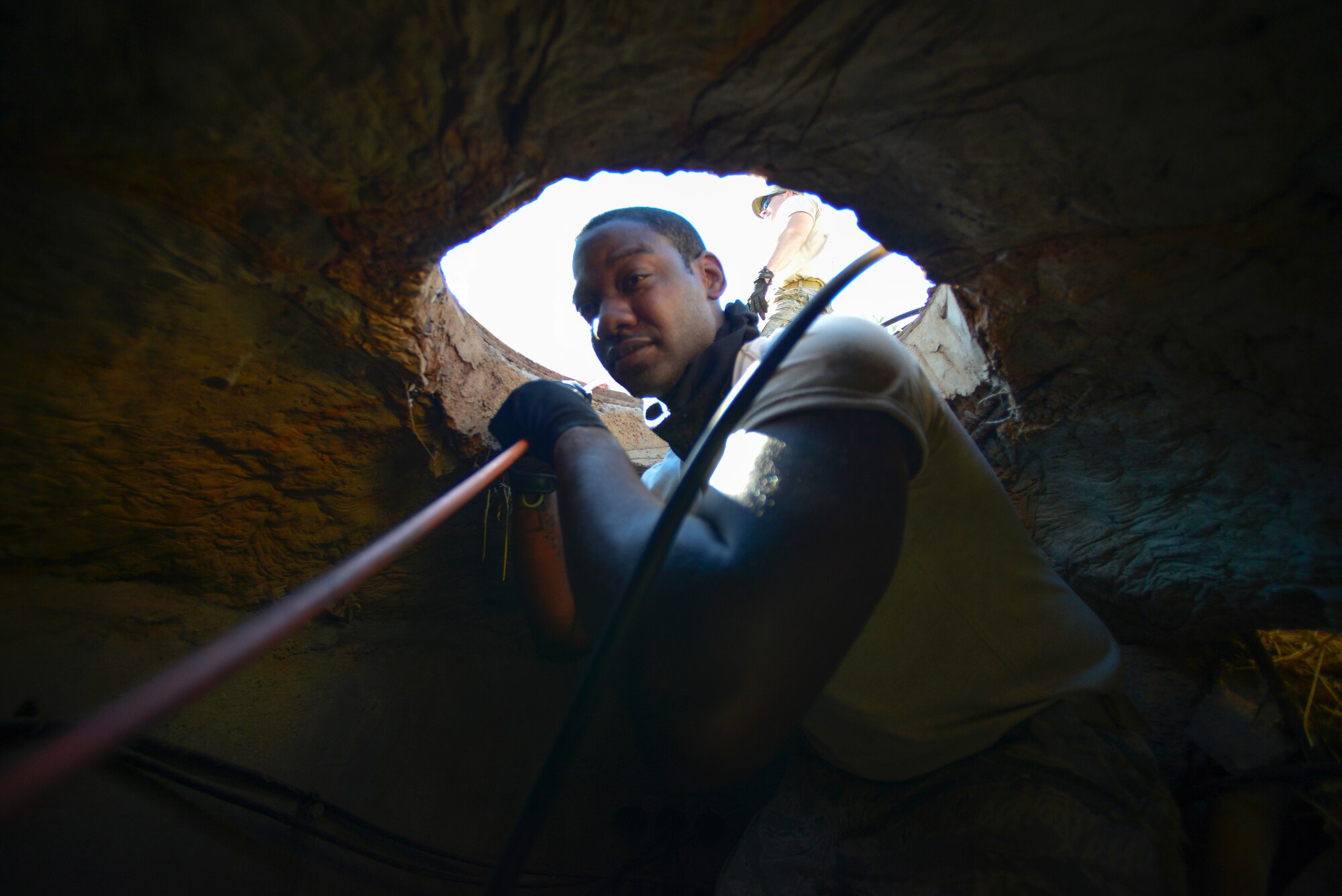 Staff Sgt. Kirk Alston, 1st Combat Communications Squadron satellite communications technician, runs a fiber optic network line through an underground pipe Oct. 5, 2015, at Diyarbakir Air Base, Turkey. A small team of communication Airmen recently deployed to Diyarbakir to build a network from scratch for all combat search and rescue operations downrange in Iraq and Syria. (U.S. Air Force photo by Airman 1st Class Cory W. Bush/Released)