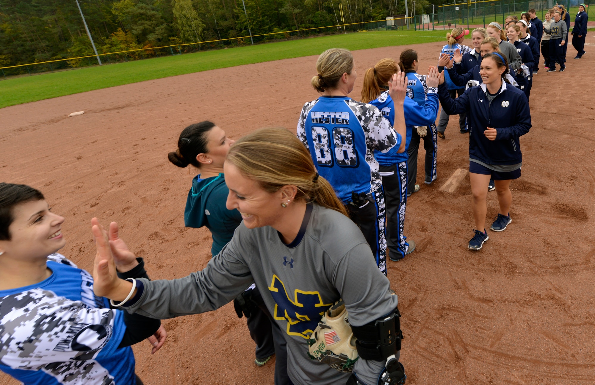 Members of the Ramstein Air Base Lady Rams and University of Notre Dame softball teams congratulate each other following a scrimmage Oct. 21, 2015, at Ramstein Air Base, Germany. The scrimmage was part of the Notre Dame softball team’s base visit during their 10-day European tour. The Lady Rams defeated Notre Dame by a score of 11-7. (U.S. Air Force photo/Staff Sgt. Sharida Jackson)