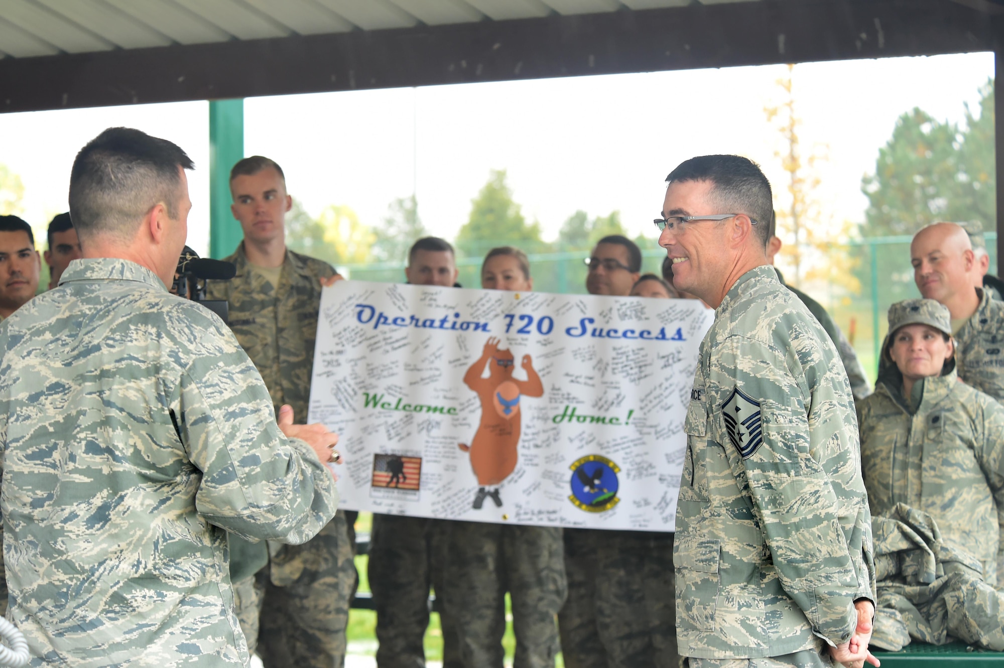 Team Buckley members celebrate Master Sgt. Troy Drasher’s, 2nd Space Warning Squadron first sergeant, homecoming Oct. 22, 2015, on Buckley Air Force Base, Colo. Drasher received national attention after completing a run from Aurora, Colo. to Abilene, Texas, in order to raise money and awareness for wounded warriors. (U.S. Air Force photo by Airman 1st Class Luke W. Nowakowski/Released)