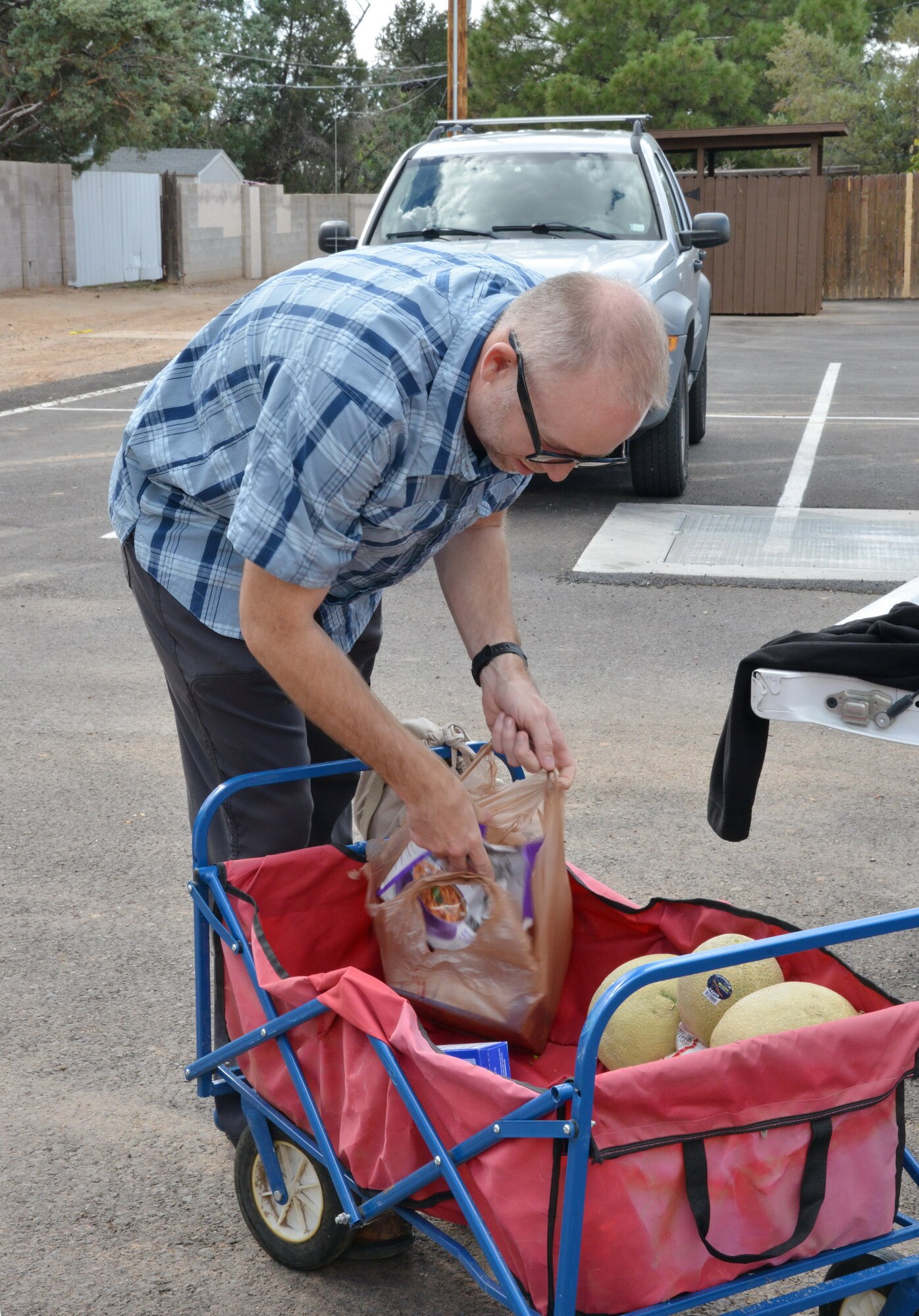 Air Force Civil Engineering Center environmental engineer Scott Clarks loads food while helping with a food distribution earlier this month at Christ United Methodist Church. Staff members at AFCEC help with the distribution every month to thank the church for allowing them to use its parking lot for monitoring and extraction wells in the process of cleaning up the jet fuel plume leaked from Kirtland several decades ago. (Photo by Jamie Burnett)