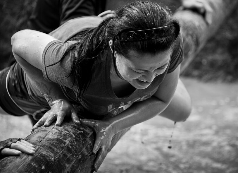 A competitor struggles to climb over a log during the Pensacola Mud Run Oct 24. Active duty and reserve service members from many local military bases came out to get dirty in the five-mile, 20-obstacle challenge.  (U.S. Air Force photo/Tech. Sgt. Sam King)