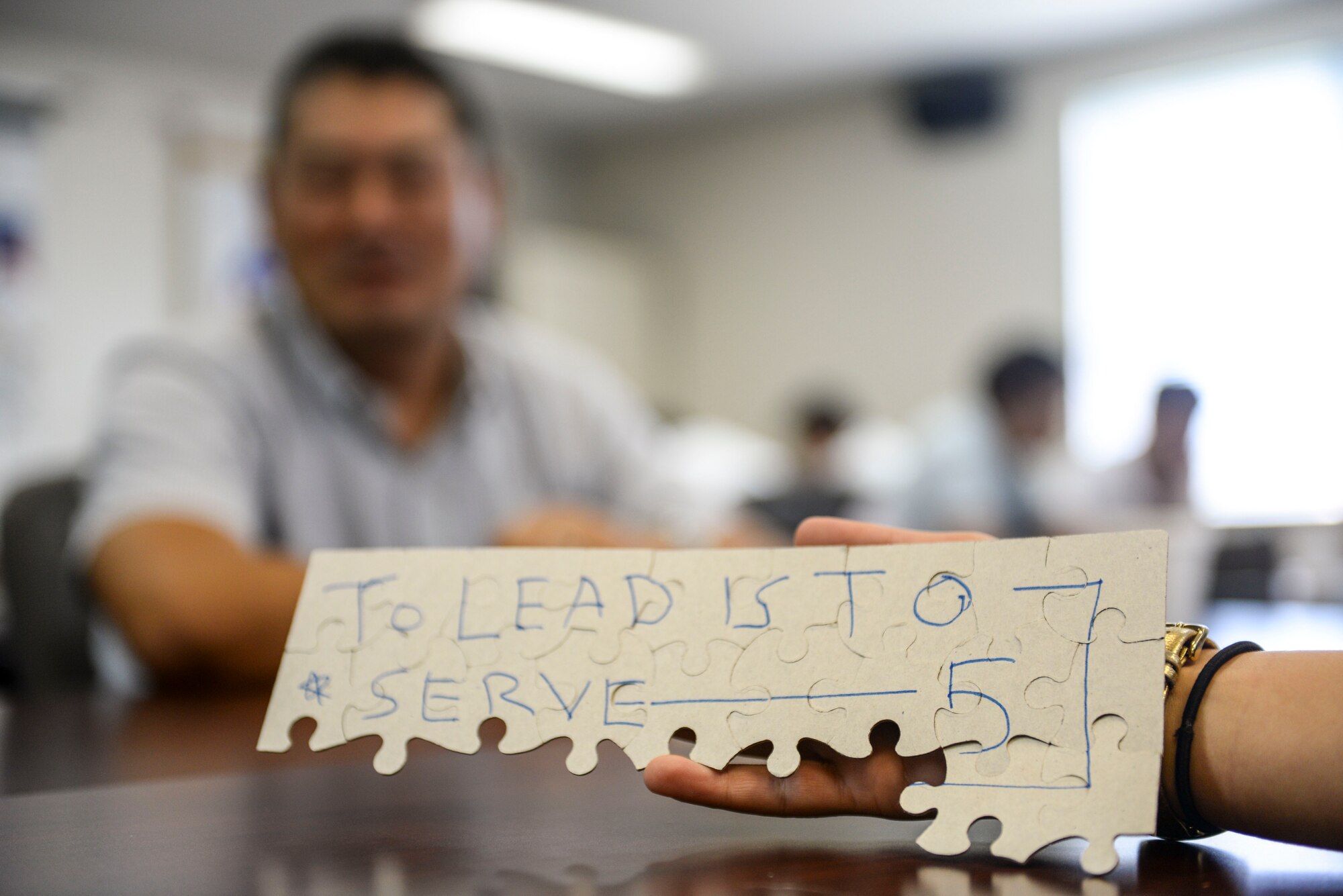 U.S. Air Force members from Kadena Air Base and Japanese Air Self-Defense Force members from the 83rd Air Wing and Southwest Air Component Division completed a puzzle in silence as part of a leadership activity during the first Bilateral Leadership Officers Group meeting Oct. 24, 2015, on Kadena AB, Japan. The completed section of the puzzle revealed a message “to lead is to serve.” The officers met together to practice language skills, socialize, learn about one another’s branch of service and become better leaders. (U.S. Air Force photo by Senior Airman John Linzmeier)