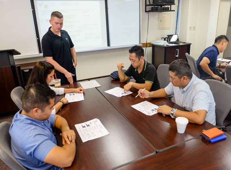 U.S. Air Force 1st Lt. Paul Buchholz, 18th Equipment Maintenance Squadron Fabrications Flight commander, speaks to U.S. officers and Japan Air Self-Defense Force officers about the differences in rank structure between their services during the first Bilateral Leadership Officers Group meeting Oct. 24, 2015, on Kadena Air Base, Japan. Members participated in a trivia-type game that tested and expanded their knowledge of each other’s services. (U.S. Air Force photo by Senior Airman John Linzmeier)