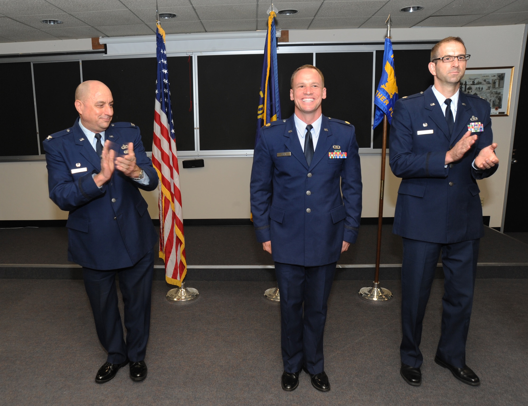 Oregon Air National Guard Combat Operations Group Commander Col. Mark Crosby, left, and Lt. Col. Matt Doggett, right, congratulate Maj. Joseph Lontai, center, after the formal exchange of colors during the Change of Command ceremony for the 123rd Weather Flight, Sept. 13, 2015, Portland Air National Guard Base, Ore. The Weather Flight Change of Command symbolized one of the last official formalities of the Combat Operations Group prior to the Oct. 1, 2015 realignment of the four units under the 142nd And 173rd Fighter Wings. (U.S. Air National Guard photo by Tech. Sgt. John Hughel, 142nd Fighter Wing Public Affairs/released)