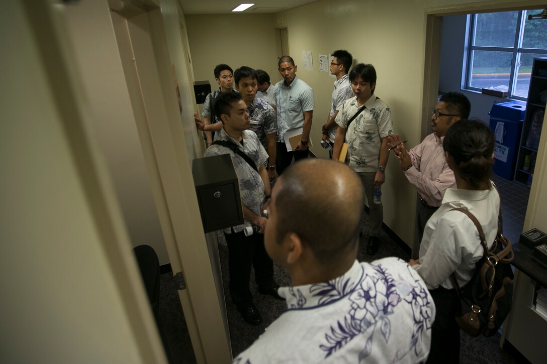 Police officers and officials with the Okinawa Prefectural Police examine an interview room during a tour of the Provost Marshal's Office Oct. 23 aboard Camp Foster, Okinawa, Japan. The visit was part of an effort by PMO and OPP to learn about one another's operations and build upon an already fruitful partnership between the two organizations, according to Sgt. Hiroki Ashitomi, an officer with the 2nd Criminal Investigation Section, OPP.