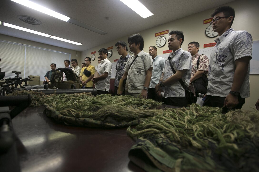 Police officers and officials with the Okinawa Prefectural Police learn about the equipment used by the Marine Corps’ Special Reaction Team during a tour of the Provost Marshal's Office Oct. 23 aboard Camp Foster, Okinawa, Japan. The visit was part of an effort by PMO and OPP to learn about one another's operations and build upon an already fruitful partnership between the two organizations, according to Sgt. Hiroki Ashitomi, an officer with the 2nd Criminal Investigation Section, OPP.