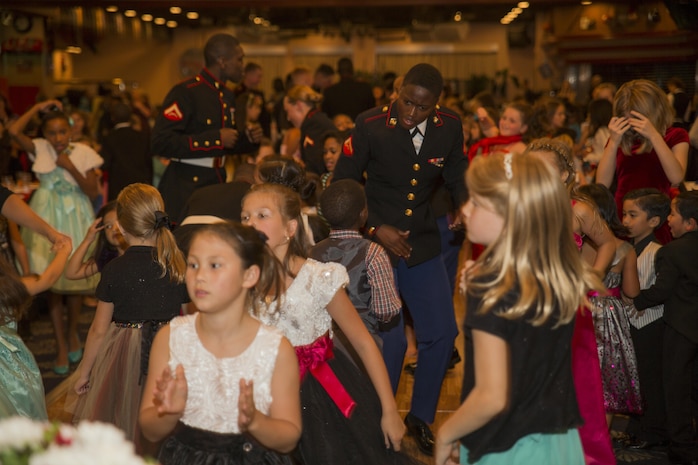 Marines and children dance during the Mini-Marine Corps Ball in the Club Iwakuni ballroom at Marine Corps Air Station Iwakuni, Japan, Oct. 23, 2015. Children dressed up, danced, ate and experienced a Marine Corps tradition during the event. The children, ranging from 5 to 12 years old, were afforded the opportunity to learn about the traditions of the Marine Corps Ball including, the cake cutting ceremony where the oldest and youngest Marine present are presented the first slice of cake.