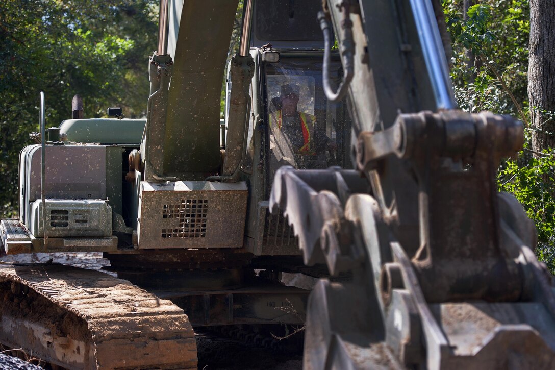 South Carolina Army National Guard Pvt. Dakota Hollman operates a 230LCR hydraulic excavator as a team of engineers works to replace a washed out culvert in Gilbert, S.C., Oct. 24, 2015. Hollman is assigned to the 125th Multi Role Bridge Company. South Carolina Army National Guard photo by Sgt. Brian Calhoun