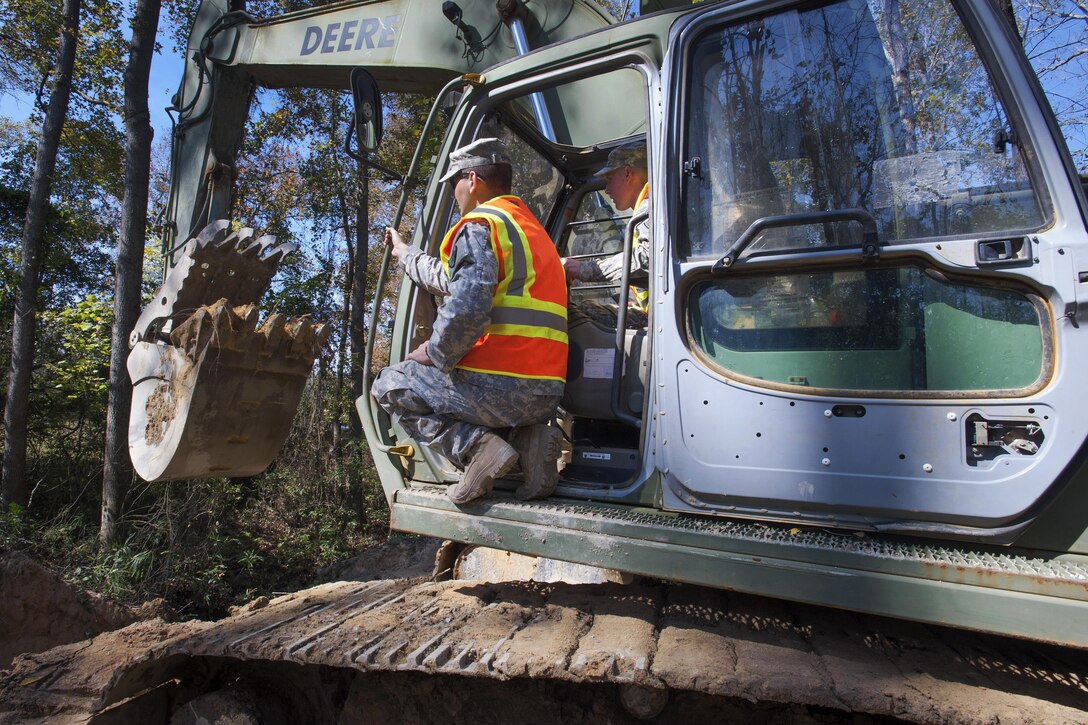 South Carolina Army National Guardsmen operate a 230LCR hydraulic excavator to replace a washed out culvert on a Lexington County road in Gilbert, S.C., Oct. 24, 2015. South Carolina Army National Guard photo by Sgt. Brian Calhoun
