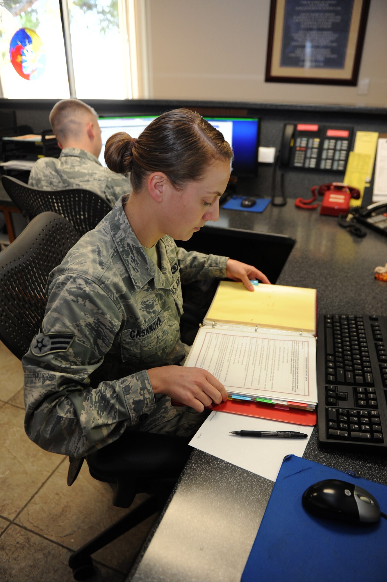 Senior Airman Monica Casanova, 56th Operations Support Squadron airfield management shift lead, references a check-list at the Luke Air Force Base airfield management office Oct 13 2015.