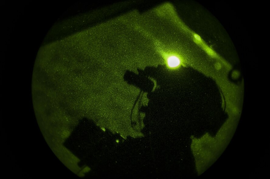 Chief Master Sgt. Barry Fegan, 8th Special Operations Squadron flight engineer instructor, scans the horizon using night-vision goggles during a training mission on a CV-22B Osprey over Hurlburt Field, Fla., Oct. 22, 2015. Osprey aircrew fly night sorties to practice using night-vision equipment and perform tactics critical to successful real-world operations. (U.S. Air Force photo by Senior Airman Ryan Conroy/Released) 