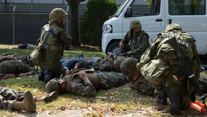 Marines and Japan Ground Self-Defense soldiers assess possible casualties in a simulated improvised explosive device explosion during Exercise Guard and Protect at Marine Corps Air Station Iwakuni, Japan, Oct. 20-23, 2015. Guard and Protect is a joint security force operation that enables readiness in case the station has to make a defense posture. The exercise tested the abilities of the Marines and Japanese soldiers to respond effectively in real world situations.
